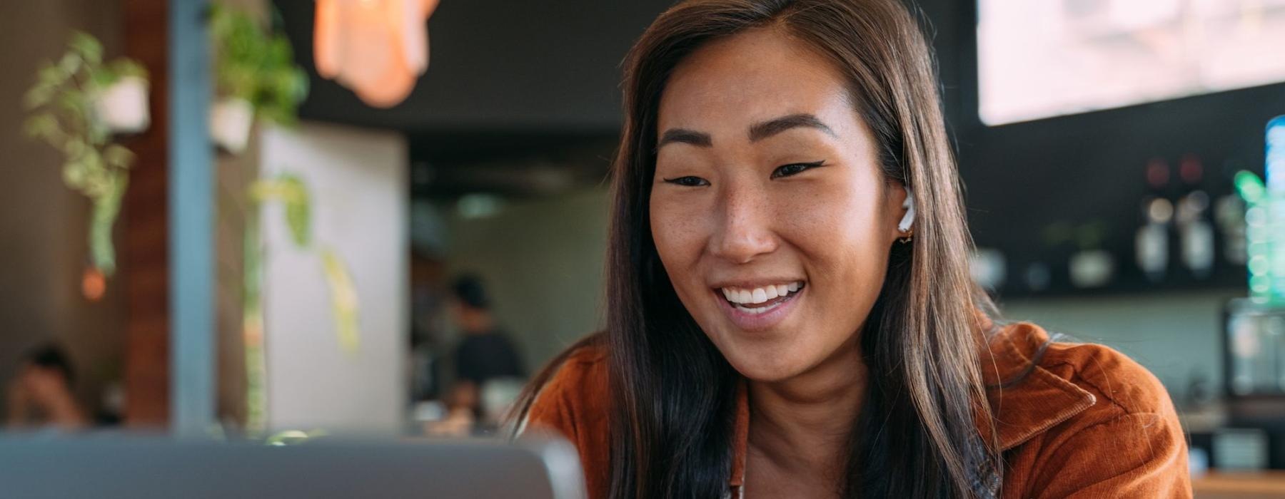 a woman smiling while working on laptop